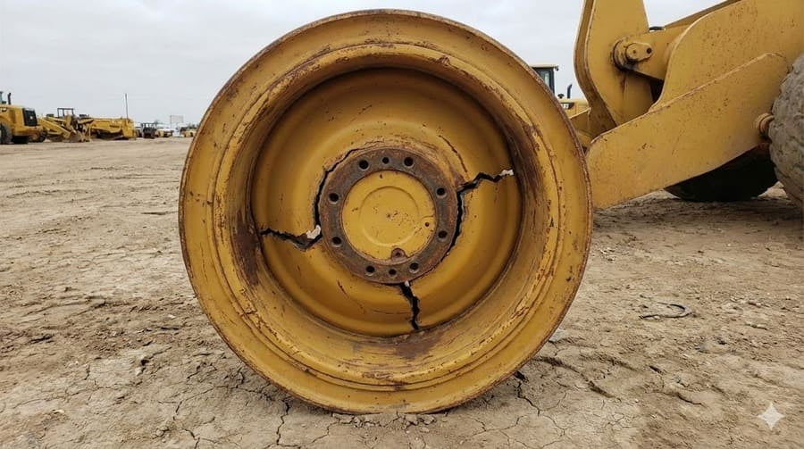 A cracked OTR wheel next to a technical drawing with correct specifications