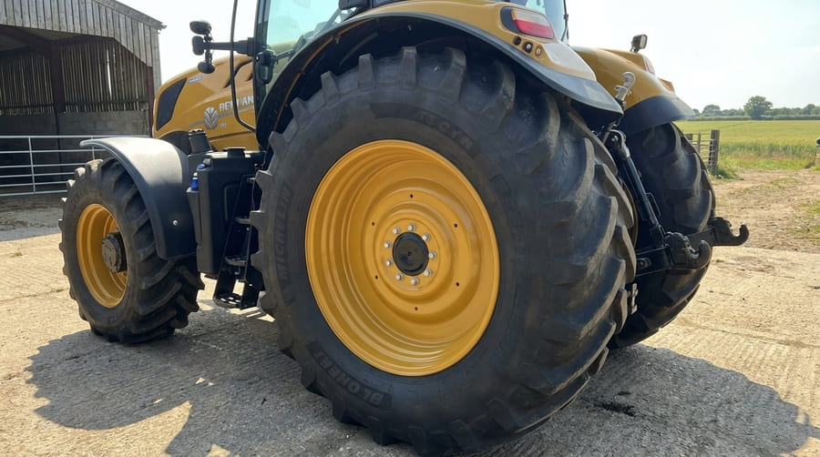 A perfectly color-matched yellow agricultural rim installed on a tractor, looking seamless and professional.