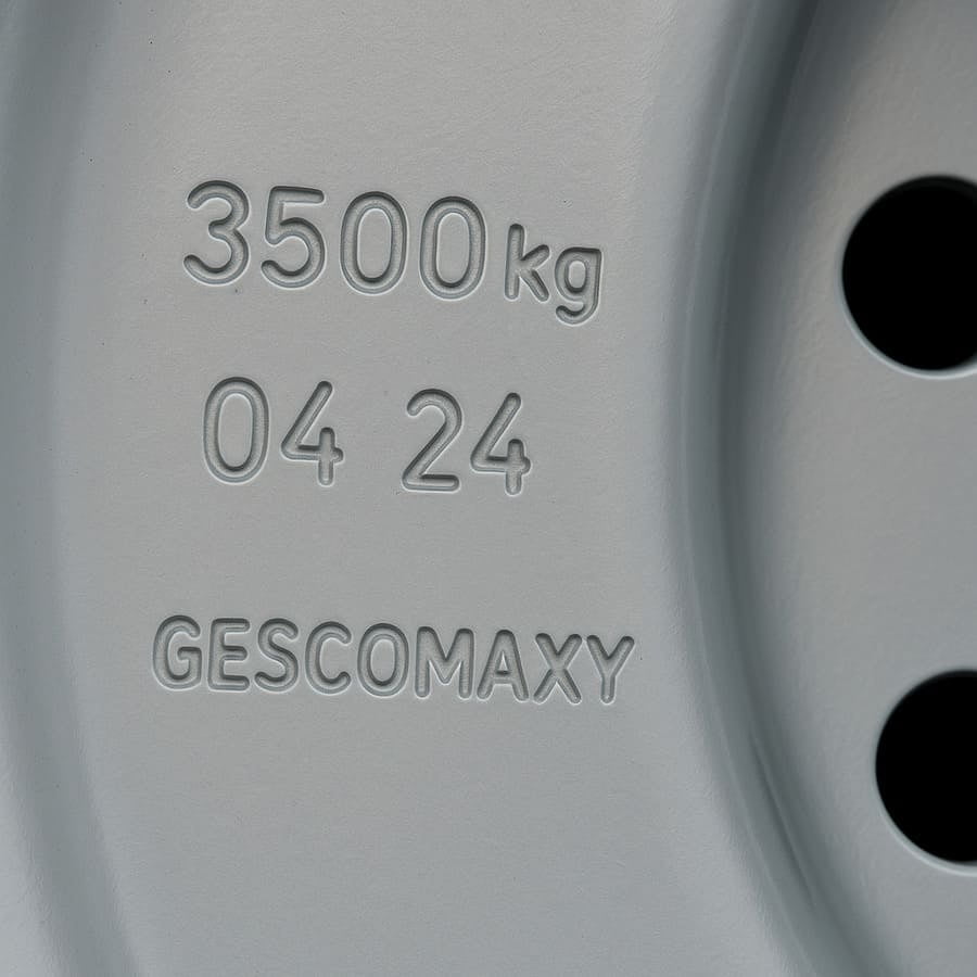 A close-up shot of a Gescomaxy wheel, clearly showing the permanent stamped markings for load, date, and logo.