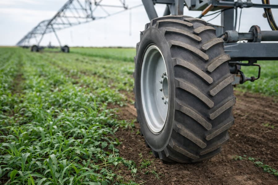 A pivot irrigation system in a field, with a focus on a tire that looks okay but is under stress.