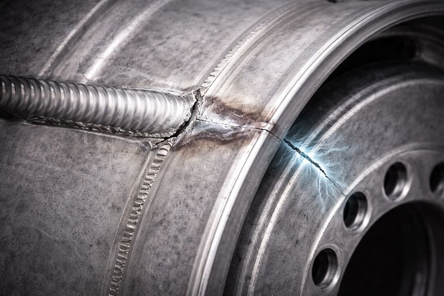 An image of a wheel with a visible weld repair, with a ghostly image of a new crack forming nearby.