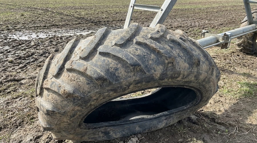 A close-up of an irrigation tire that is visibly deformed but not burst.