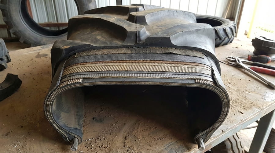 A cutaway view of an irrigation tire showing its internal ply layers and structure.