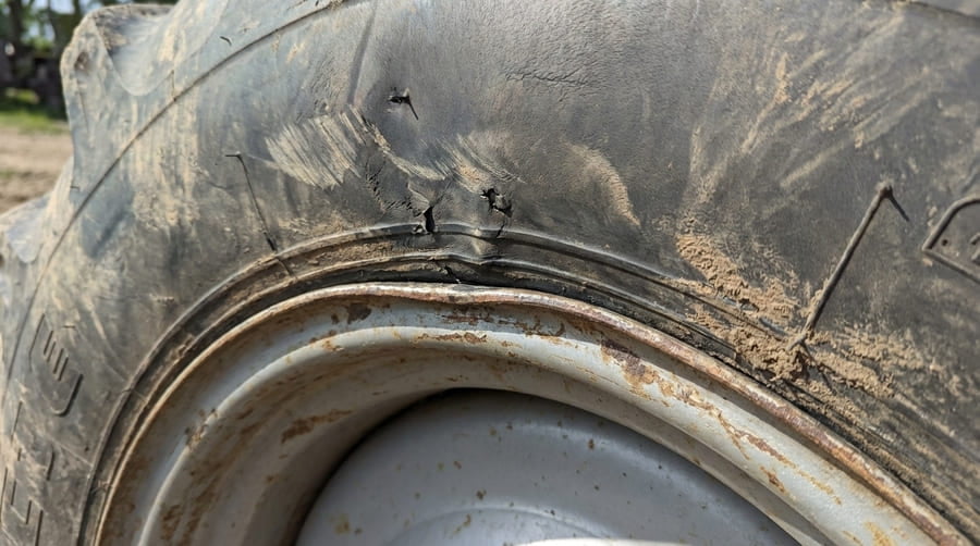A close-up of a tire bead area showing stress marks and damage near the rim.